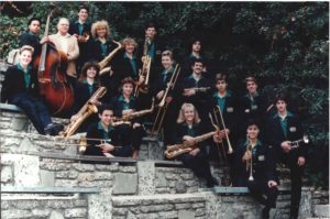 One of the succsession of fine Eagle Rock High School Stage Bands (directed by John Rinaldo, behind the bass) is posed here in 1987. of interest in the foreground are the remaining original wooden seating.-ERVHS,ND.