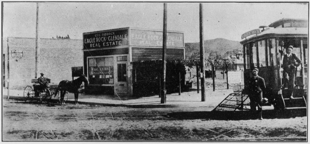 George Diddock's real estate office is on the southwest Corner of Eagle Rock and Colorado in 1909. Both streets are still unpaved. The side of the College Inn building is visible on the right. In the center right the newly built Eagle Rock School is visible in the distance. On the left is the Los Angeles Railways trolley from downtown, heading for the end of the line at Townsend Avenue (Published in the Los Angeles Herald Sunday Magazine)
