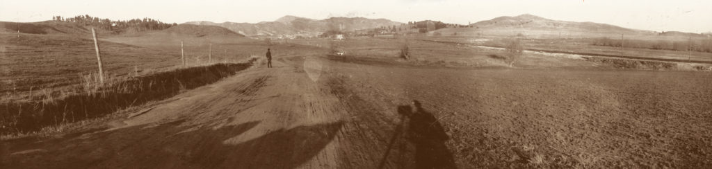Architect Myron Hunt surveys the area where Occidental College would be built. The streetcar line runs straight along the right side of the photograph. Drains channel the water under the road and the tracks from the low-lying area that made travel to downtown by road unreliable. (Occidental College Library Special Collections)