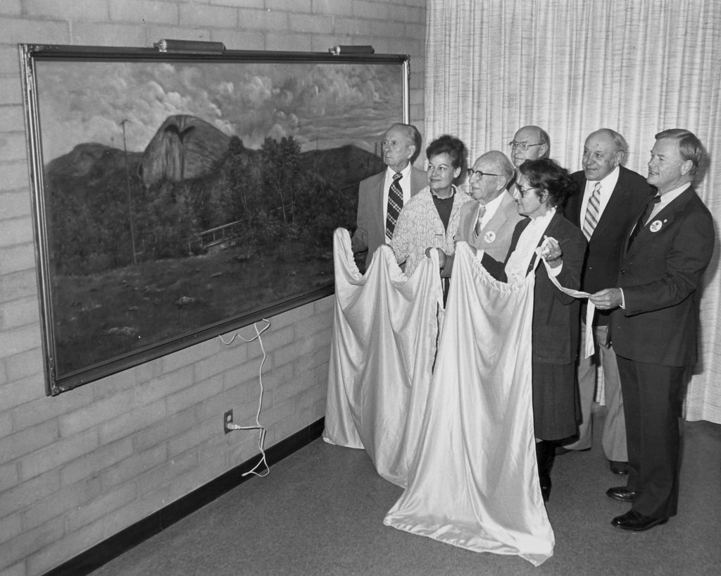 This painting, by Jennie C. Brayton, was discovered behind Arroyo Furniture in Highland Park and restored by the society. Here it is being loaned for display in the new Eagle Rock Branch Library. From left; unknown man; Virginia Ruzica, restoration artist; Carroll Evans, financial sponsor; Ralph Sherman, past president of ERVHS; and Lois Woods, then-president unveil the painting in the community room of the library. (probably Joe Friezer -ERVHS)